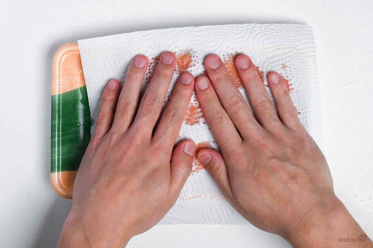 patting salmon fillets dry with kitchen paper