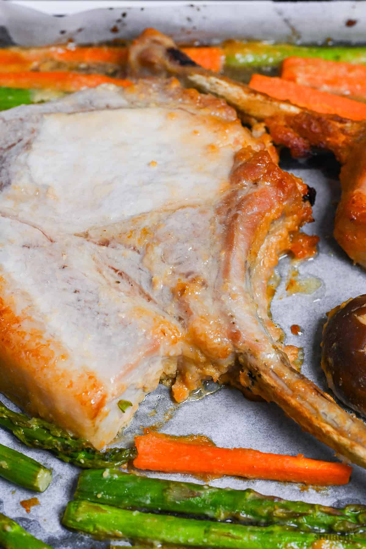 Miso marinated pork chop and vegetables on a baking sheet lined with baking paper