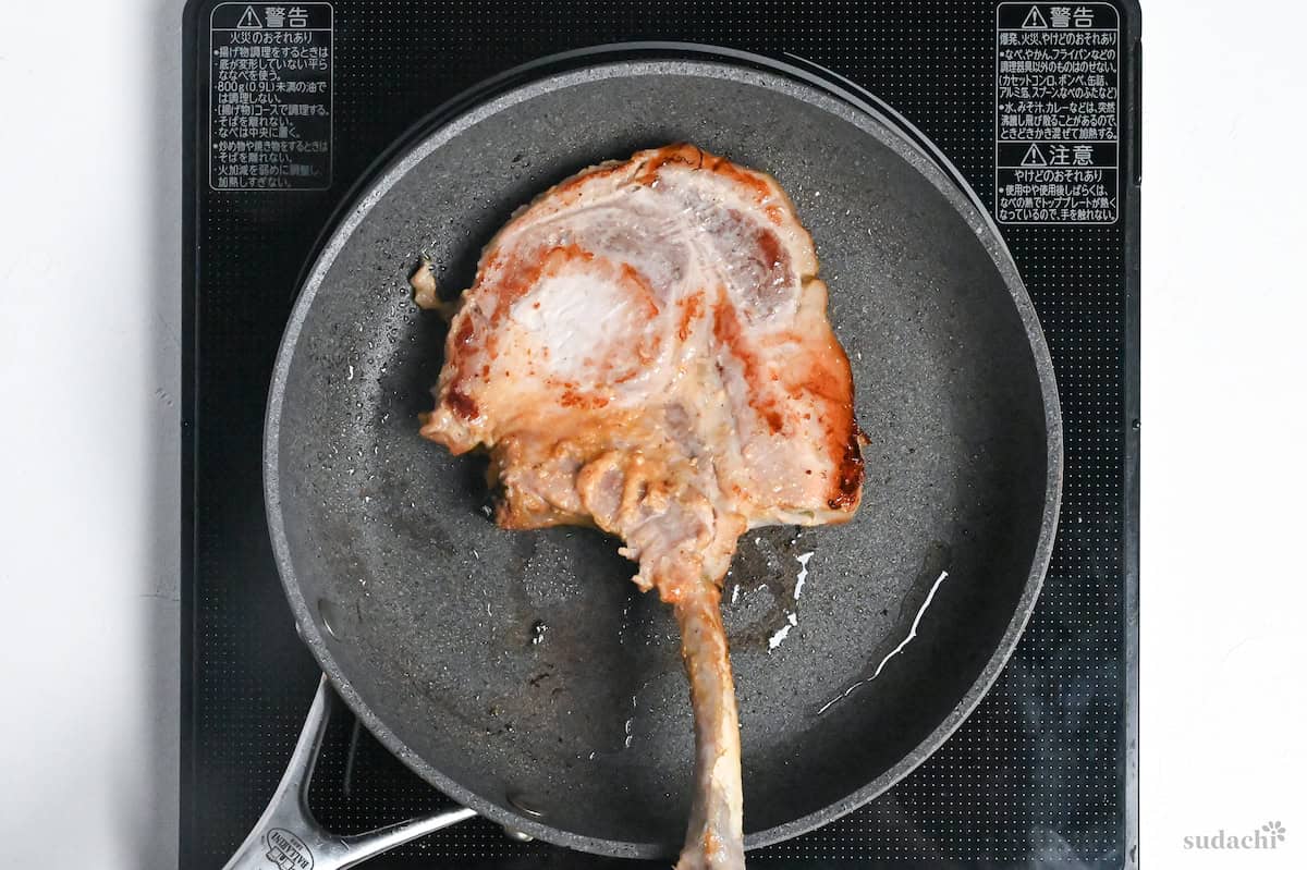 searing miso marinated pork chop in a frying pan