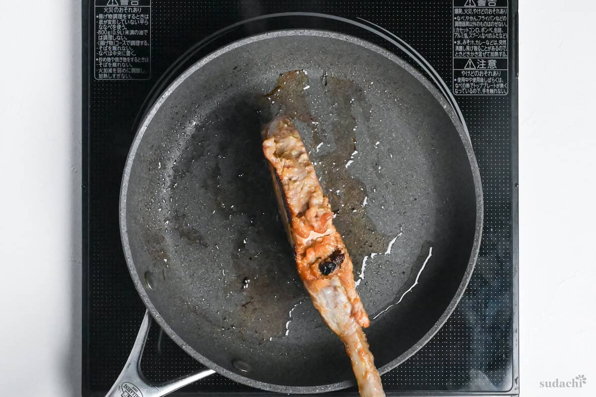 searing edges of pork chop in a frying pan