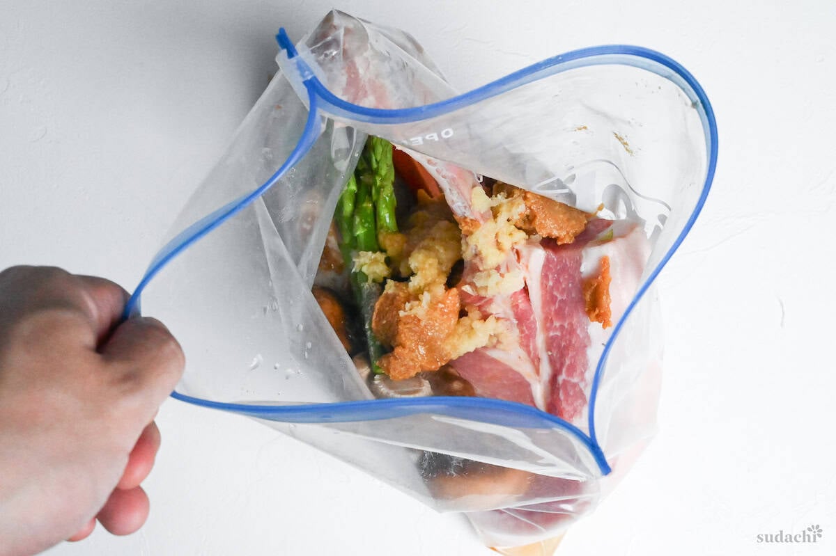 pork chops and vegetables in a sealable freezer bag with miso marinade