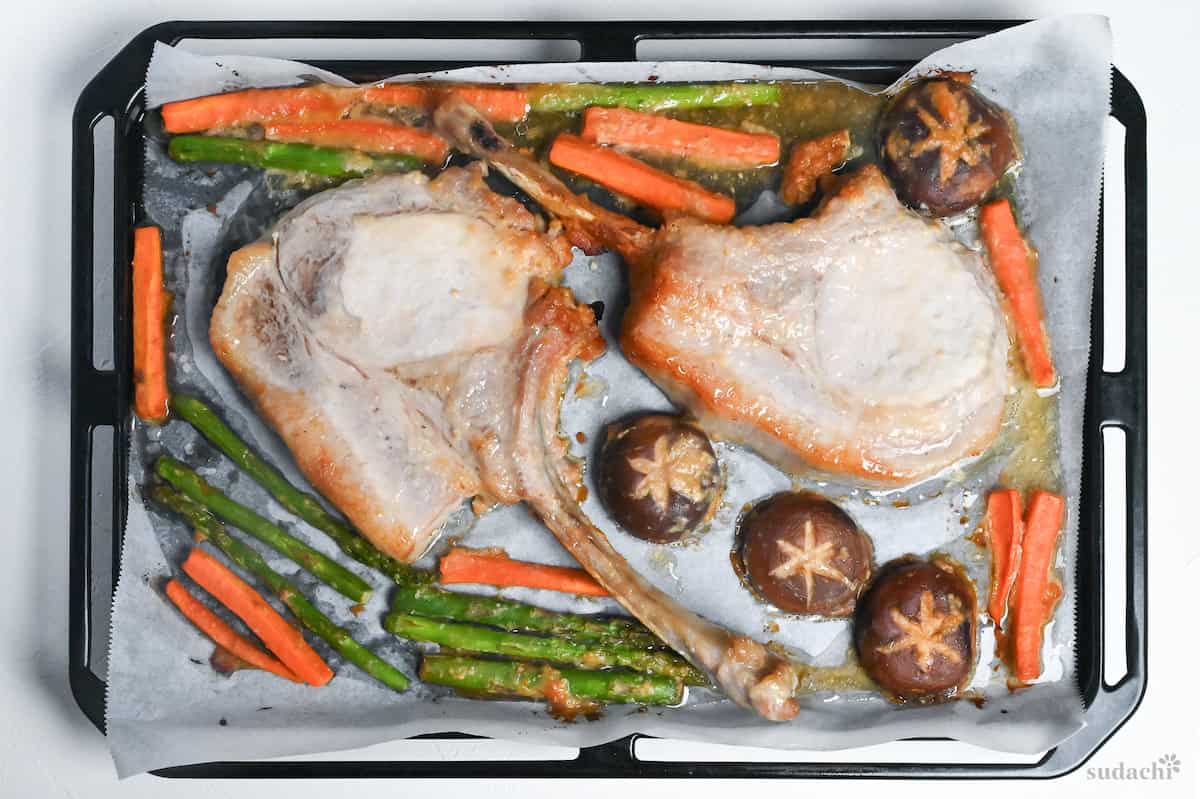 Pork and vegetables baked at a low temperature on a baking sheet