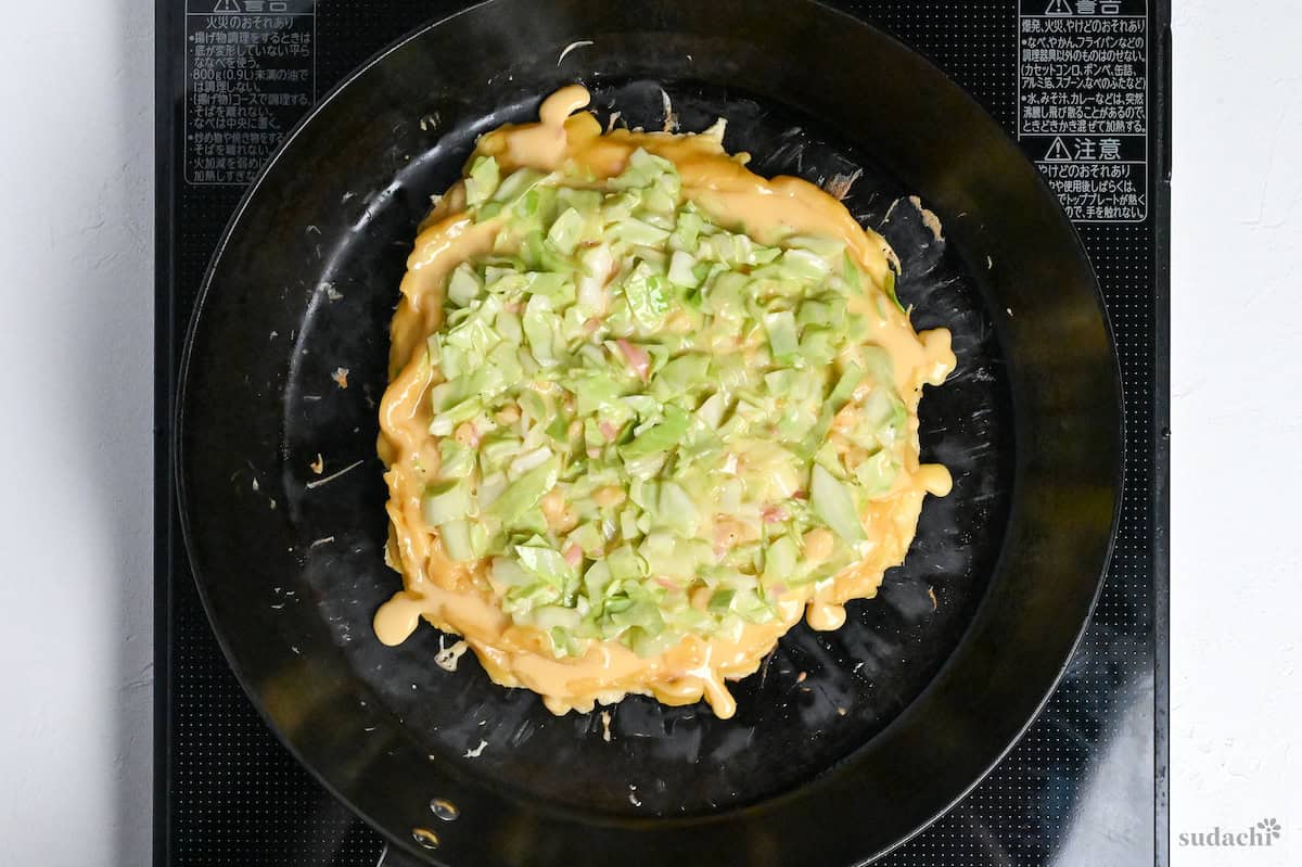 okonomiyaki frying in a cast iron pan