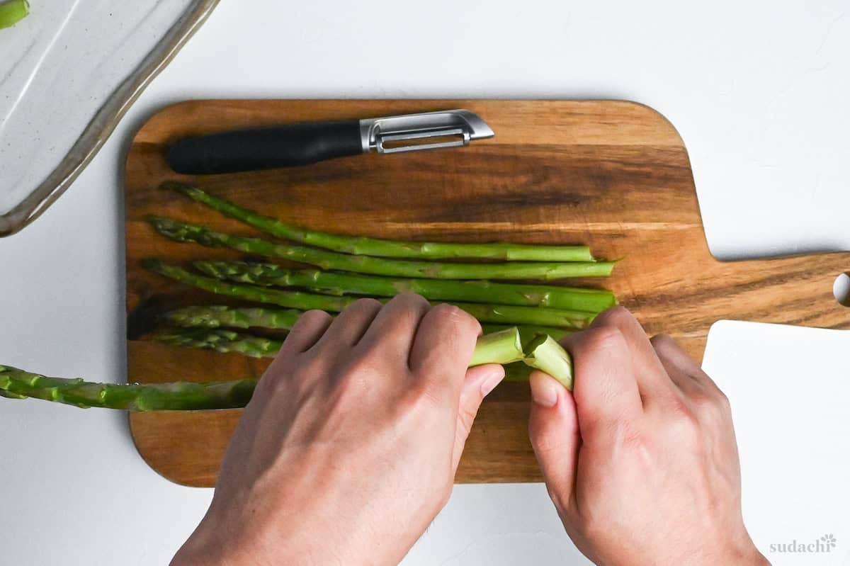 Breaking woody base off of asparagus stems