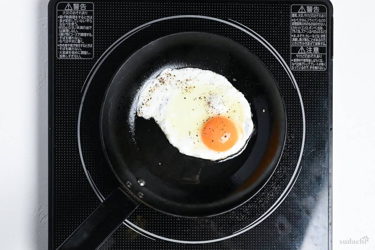 frying an egg in a pan on the stove top