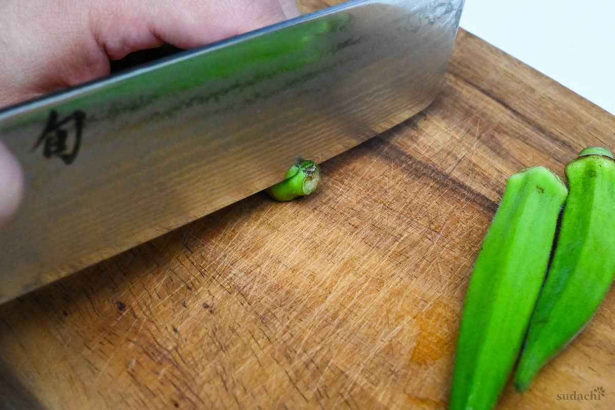 Trimming the top stem off of okra