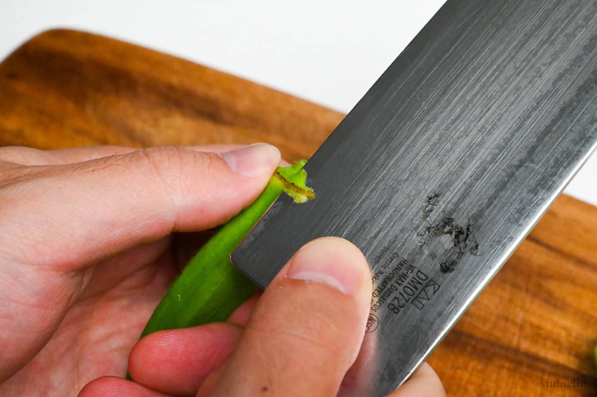 peeling the top of one okra