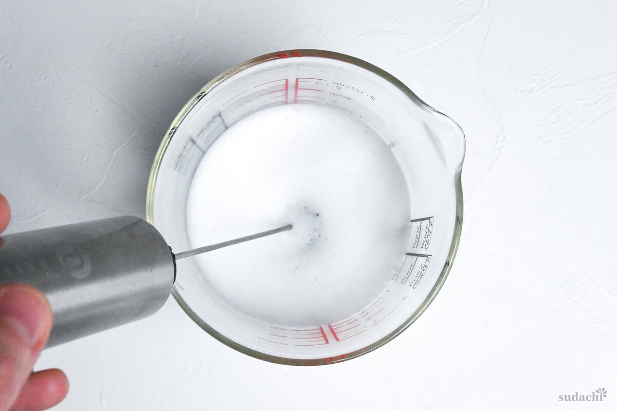 frothing milk in a glass jug
