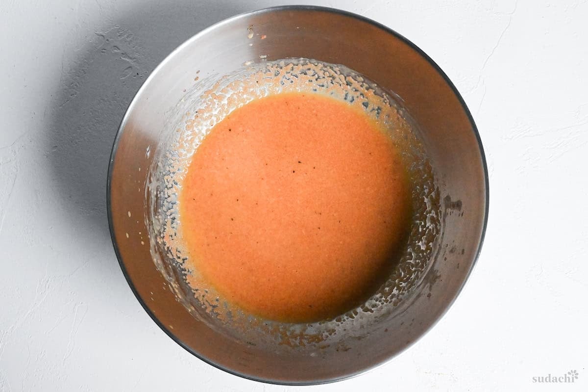 mentaiko pasta sauce in a steel mixing bowl on a white surface