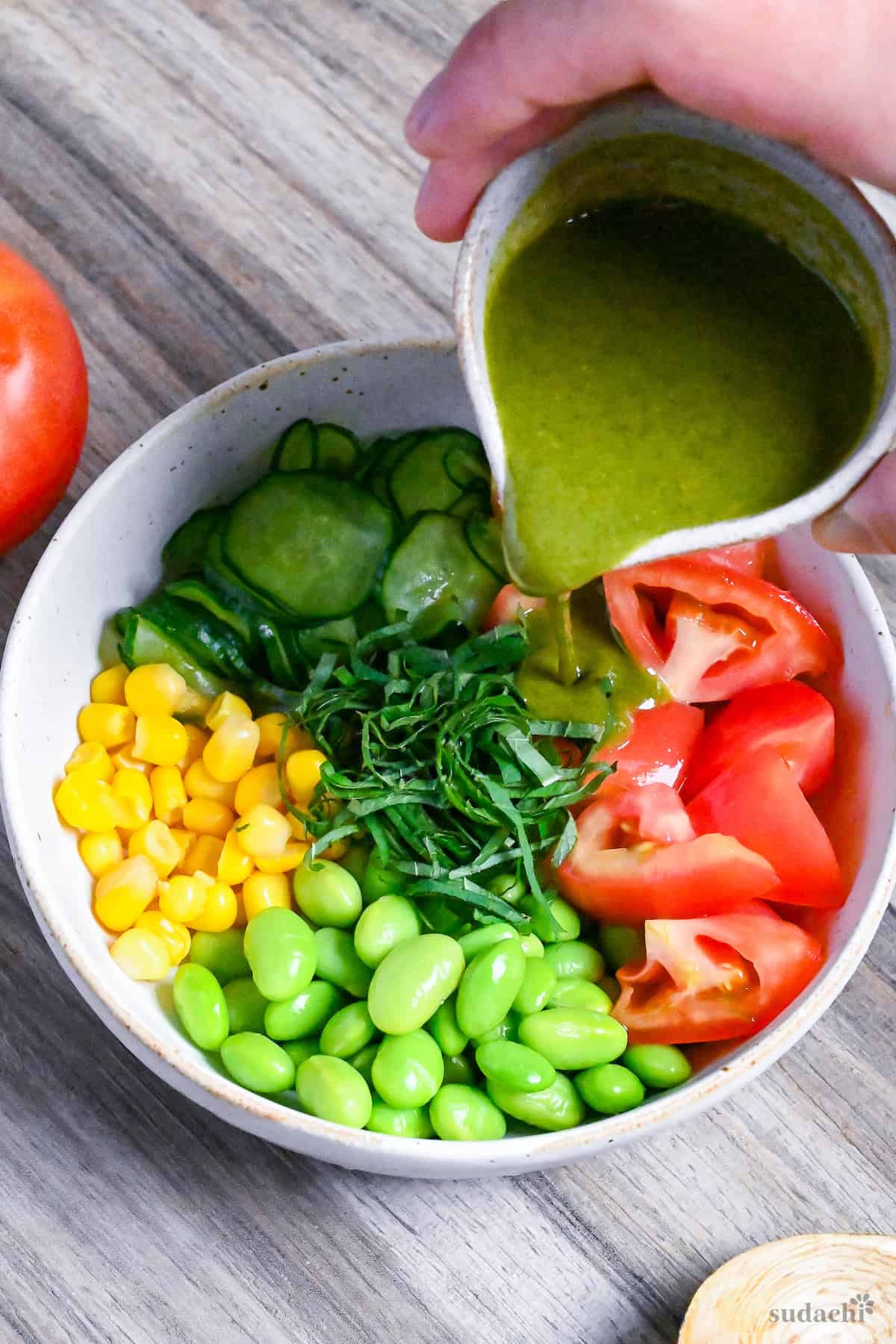 pouring shiso dressing over summer vegetable salad
