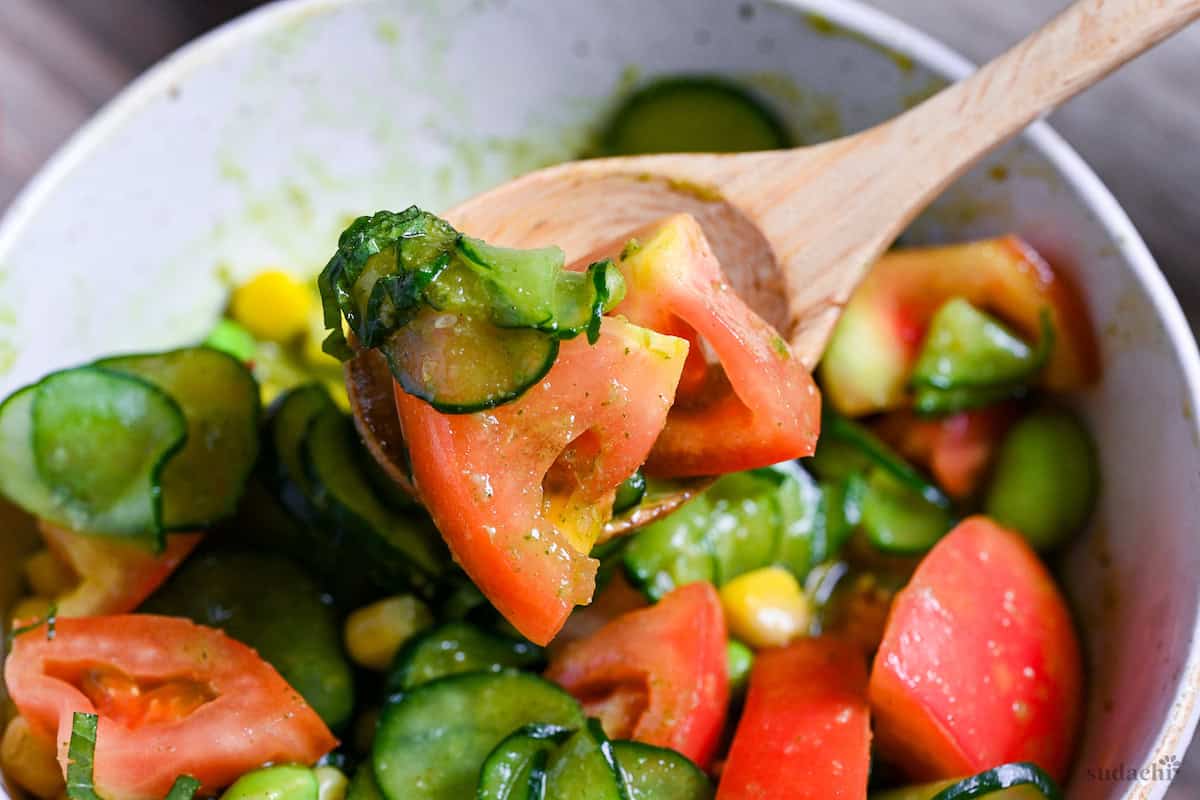 summer dressing salad with shiso dressing on a light wooden spoon