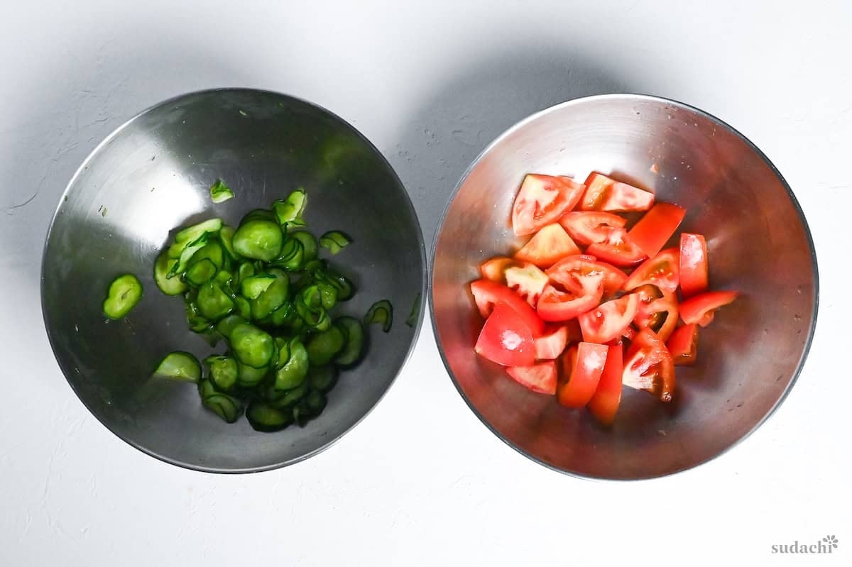 salted cucumber and tomatoes in separate bowls