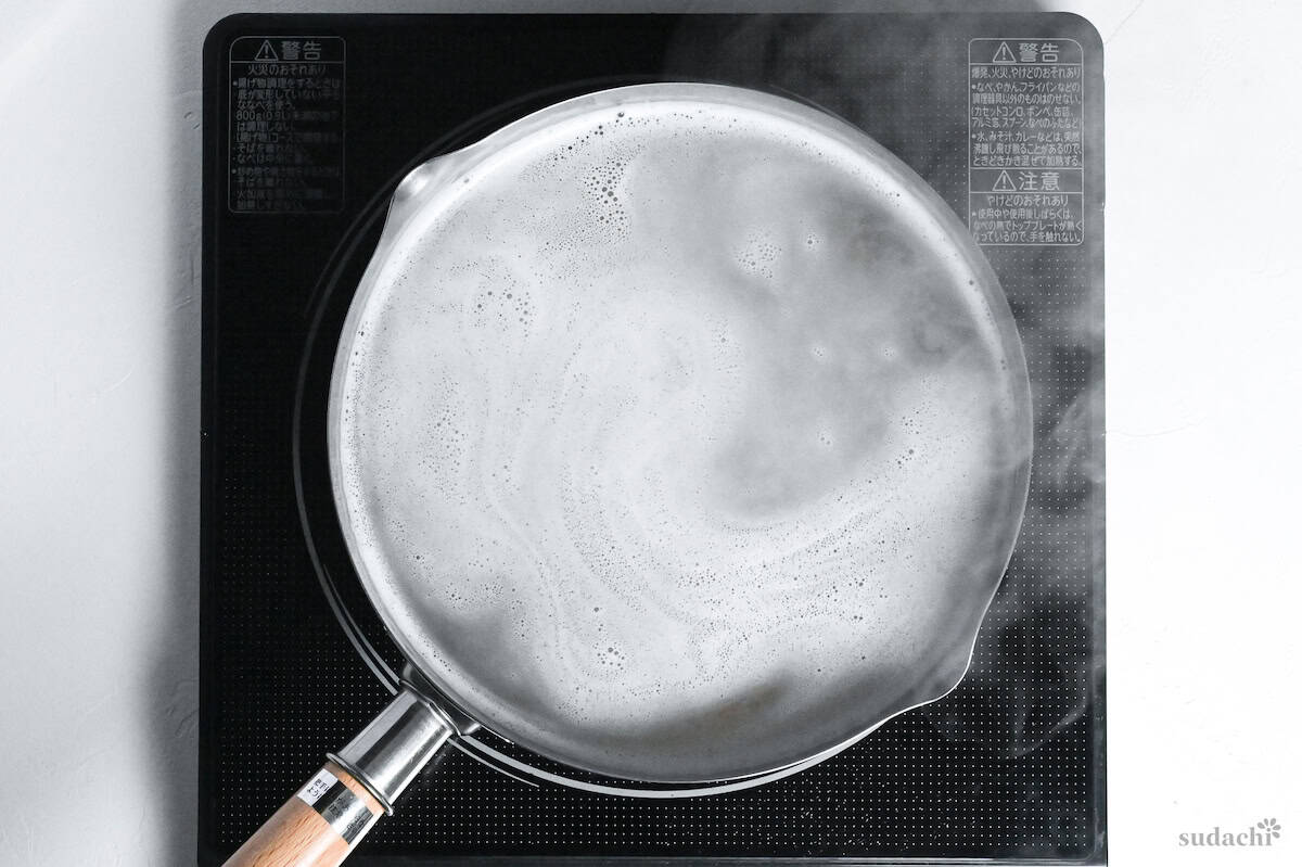 soba noodles cooking in a pot of water on the stove top
