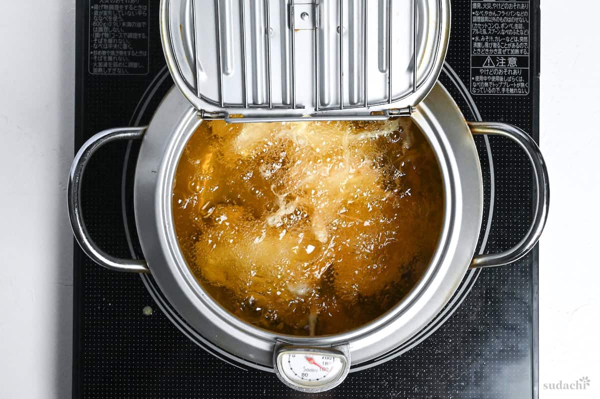 chicken frying in a pot of oil