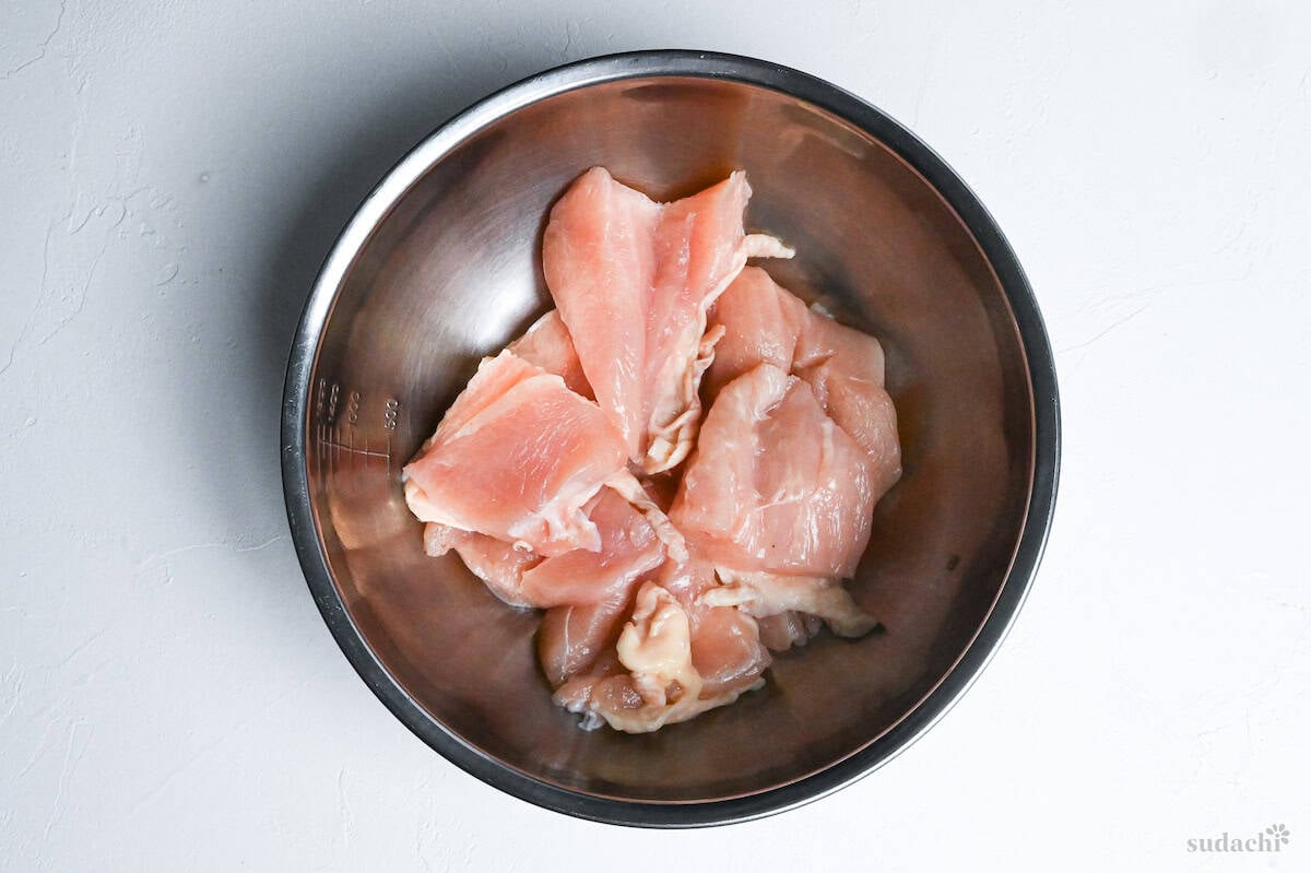 chicken breast pieces in a steel mixing bowl