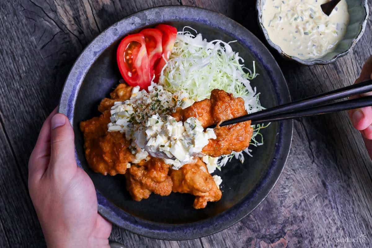 final plating of chicken nanban with shredded cabbage, tomato wedges and tartar sauce