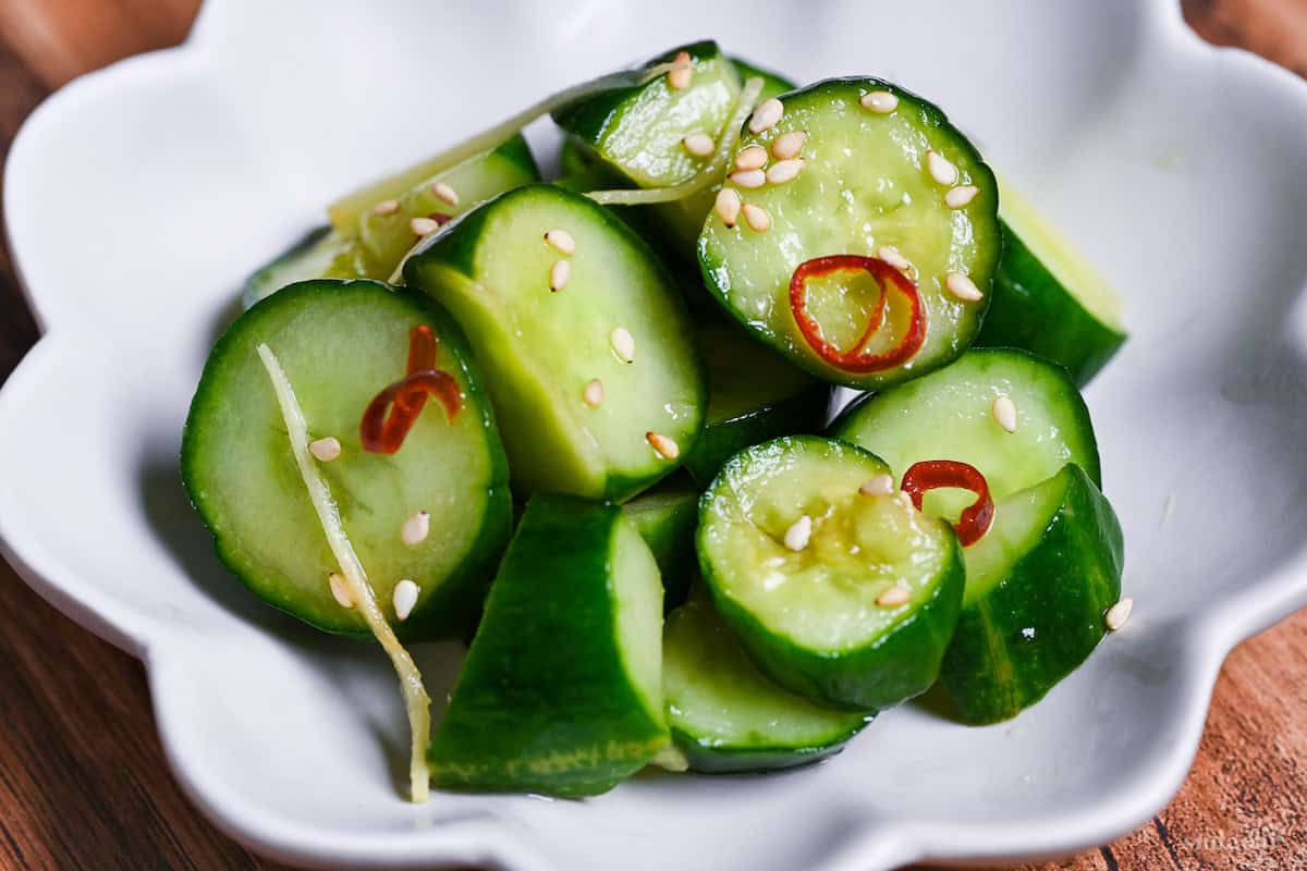 Complete Japanese pickled cucumber with ginger and chili sprinkled with sesame seeds in a small white serving dish