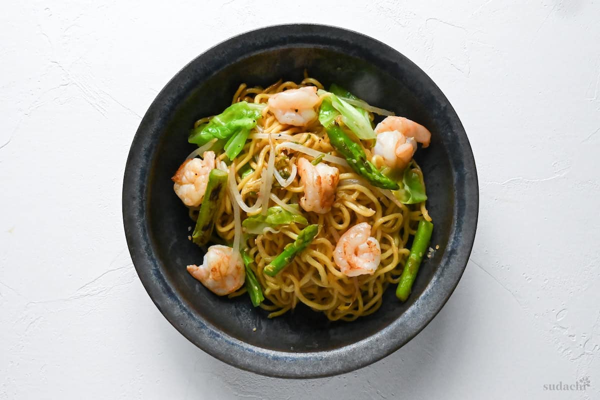 Shio Lemon Yakisoba in a blue/black iridescent bowl on a white background