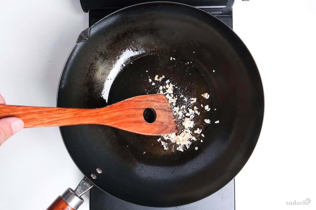 finely diced garlic frying in oil in a wok