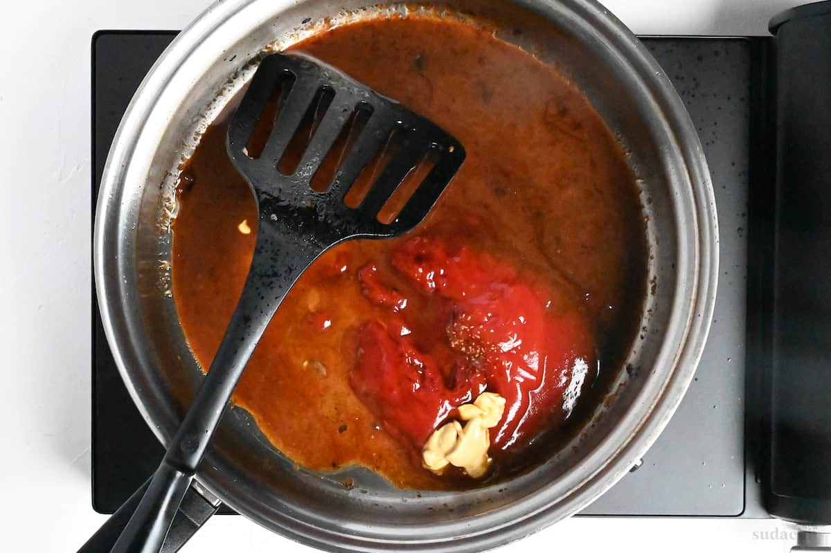 adding ingredients to a stainless steel pan to make hamburg sauce