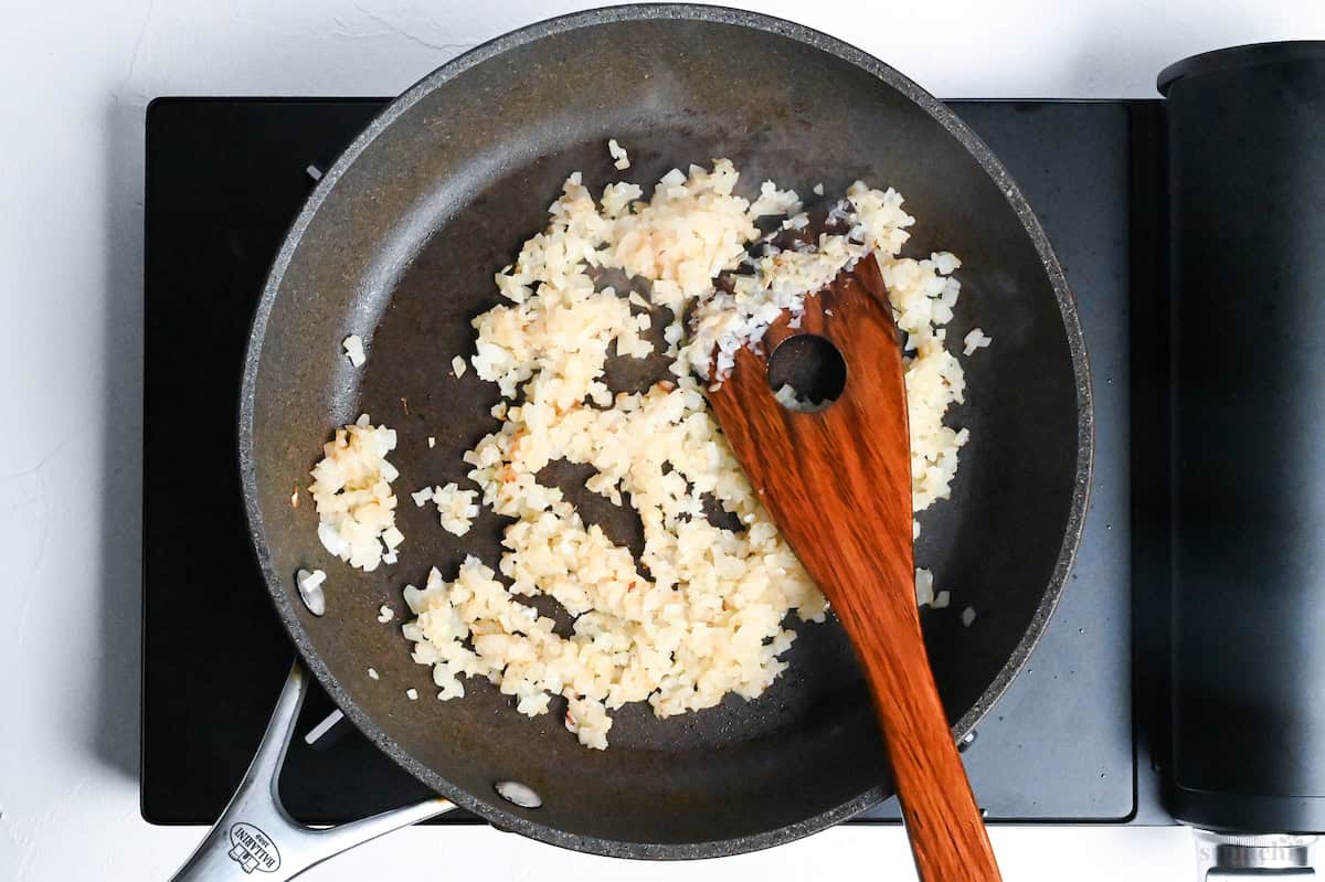 lightly golden onion in a frying pan
