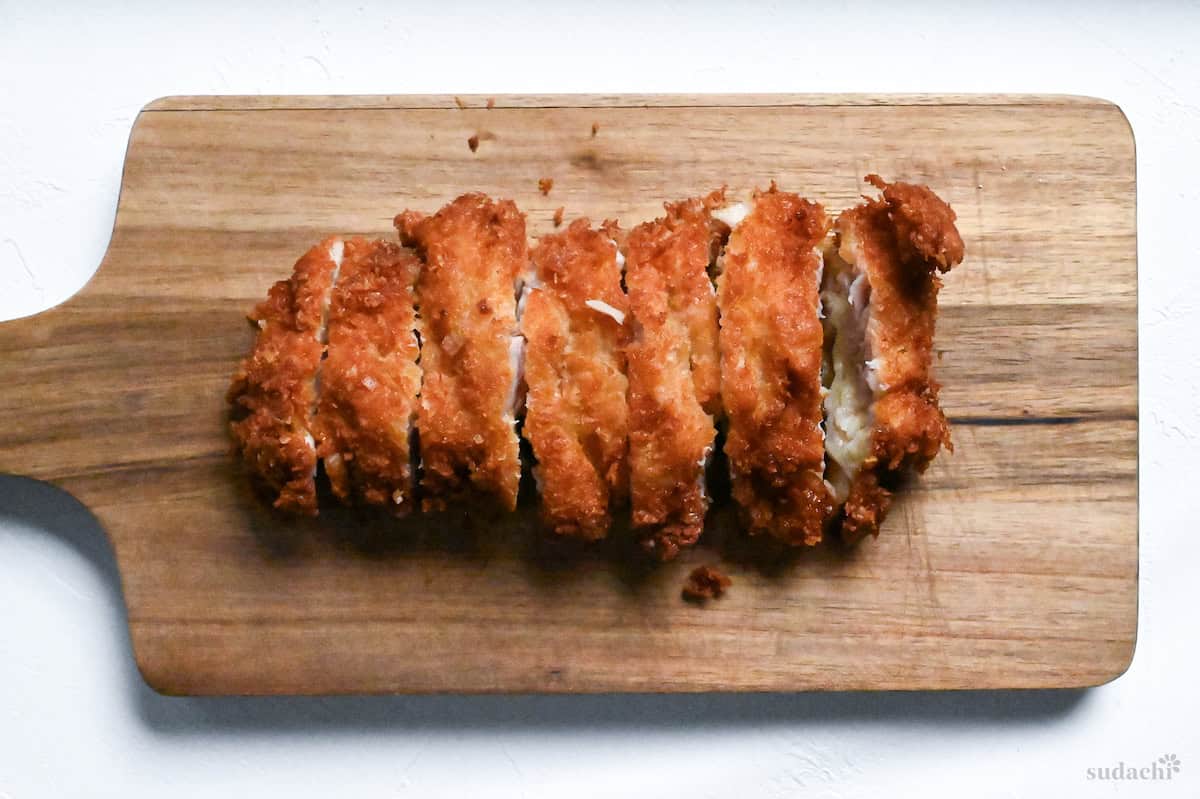 chicken katsu cut into strips on a wooden cutting board