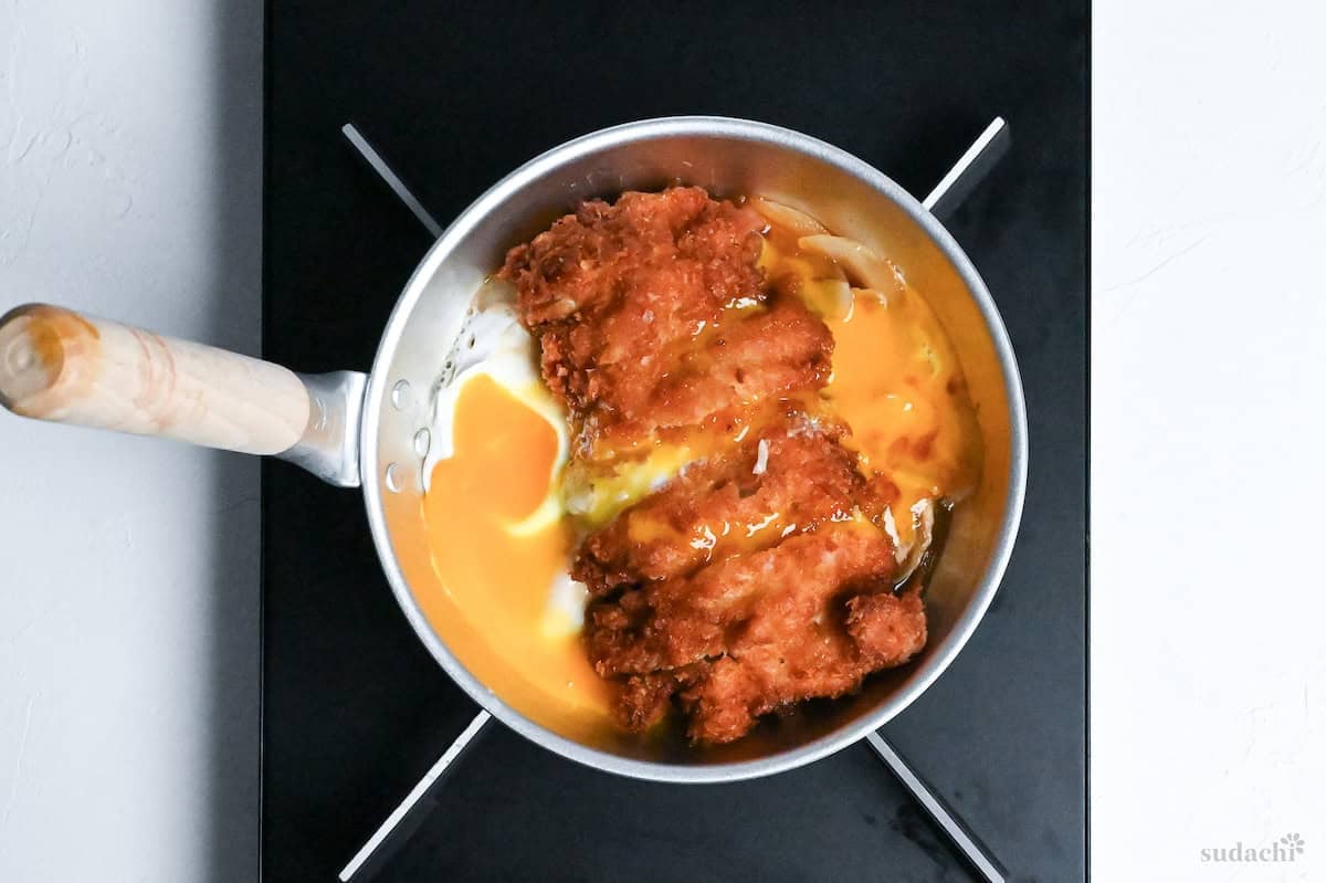 chicken cutlet and egg with dashi and egg in a Japanese style pan on the stove top