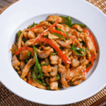 Japanese pepper steak stir fry (chinjao rosu) served in a white dish on a woven placemat thumbnail