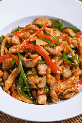 Japanese pepper steak stir fry (chinjao rosu) served in a white dish on a woven placemat thumbnail