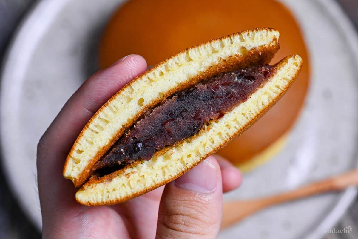 holding half a dorayaki revealing red bean paste (anko) inside