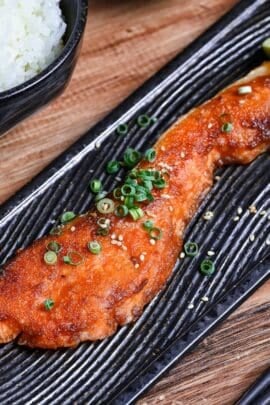 Miso glazed salmon on a long rectangular black plate with a wave design thumbnail