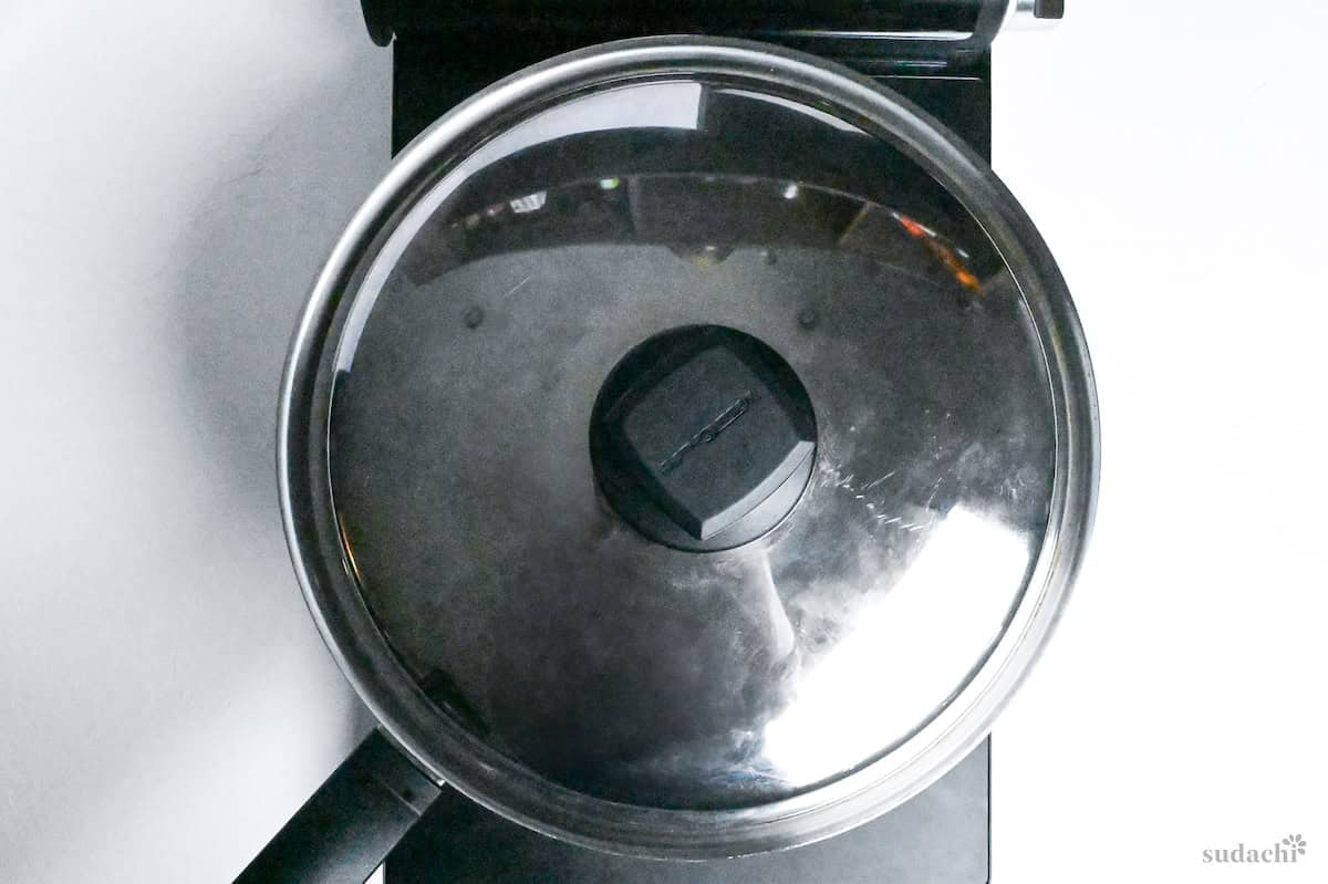 Tonteki pork steaks in a stainless steel pan with a lid on