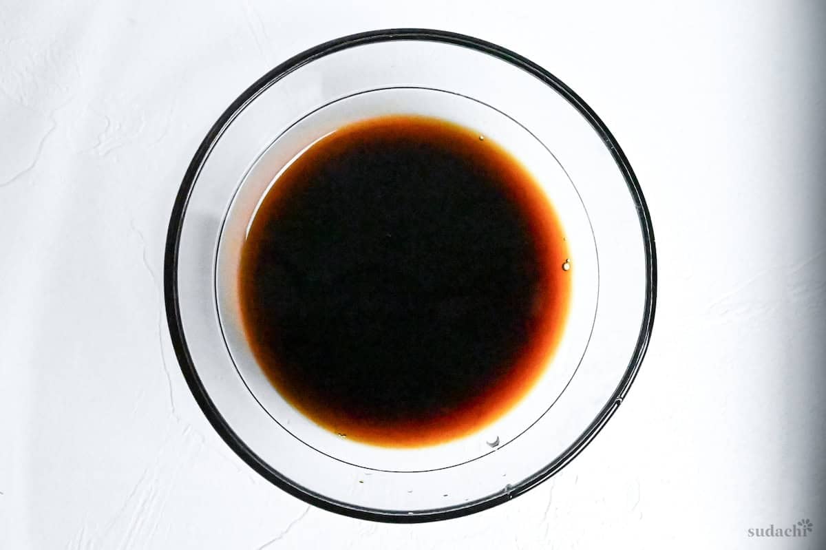 Tonteki pork steak sauce mixed in a small glass bowl on a white background