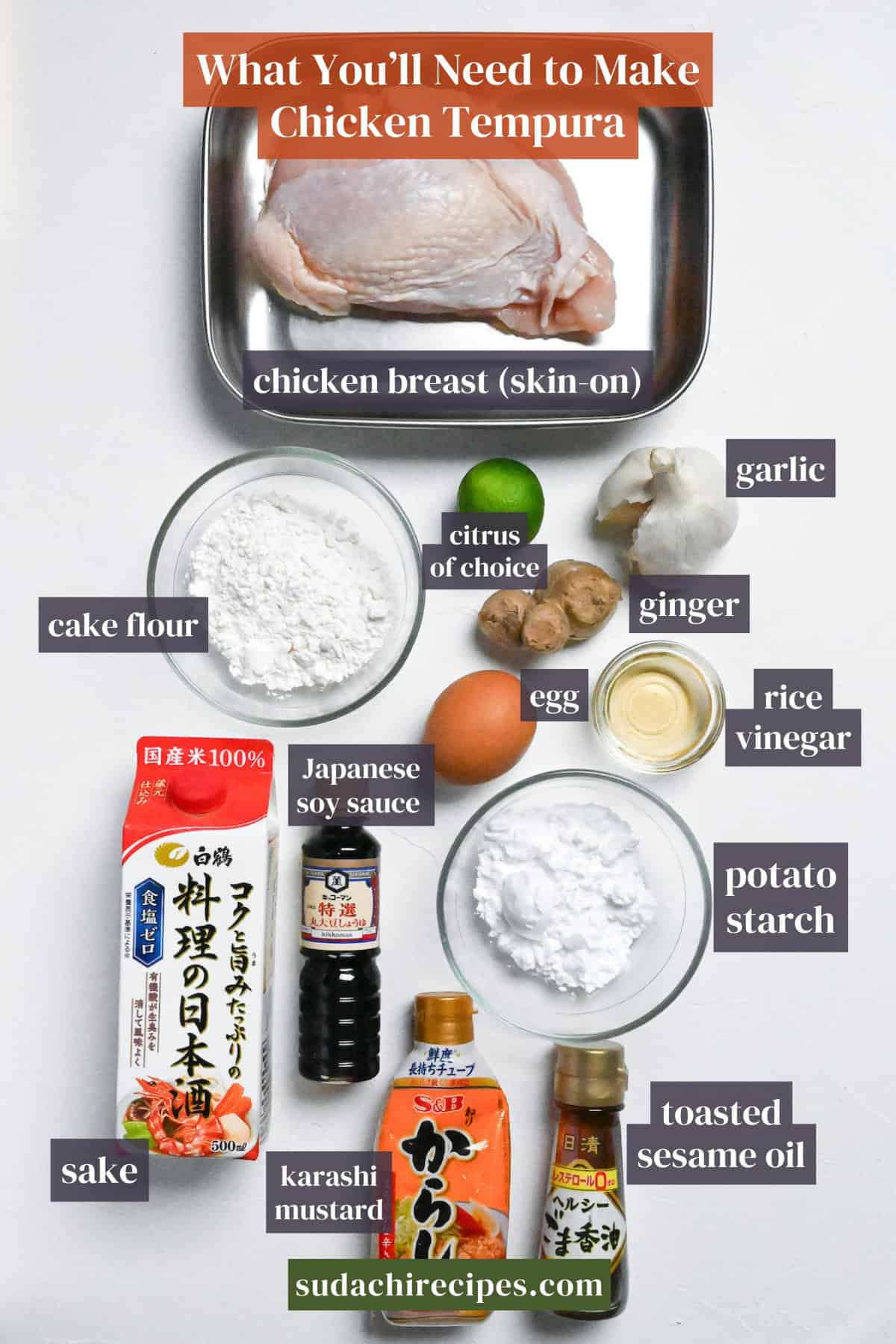 Ingredients needed to make chicken tempura on a white background. From top to bottom, left to right: chicken breast, cake flour, citrus, garlic, ginger, egg, rice vinegar, Japanese soy sauce, sake, potato starch, karashi mustard, toasted sesame oil