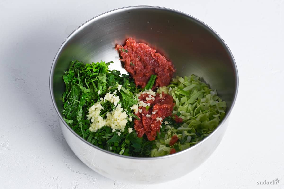 vegetables and aromatics finely chopped in a bowl to make chicken gyoza filling