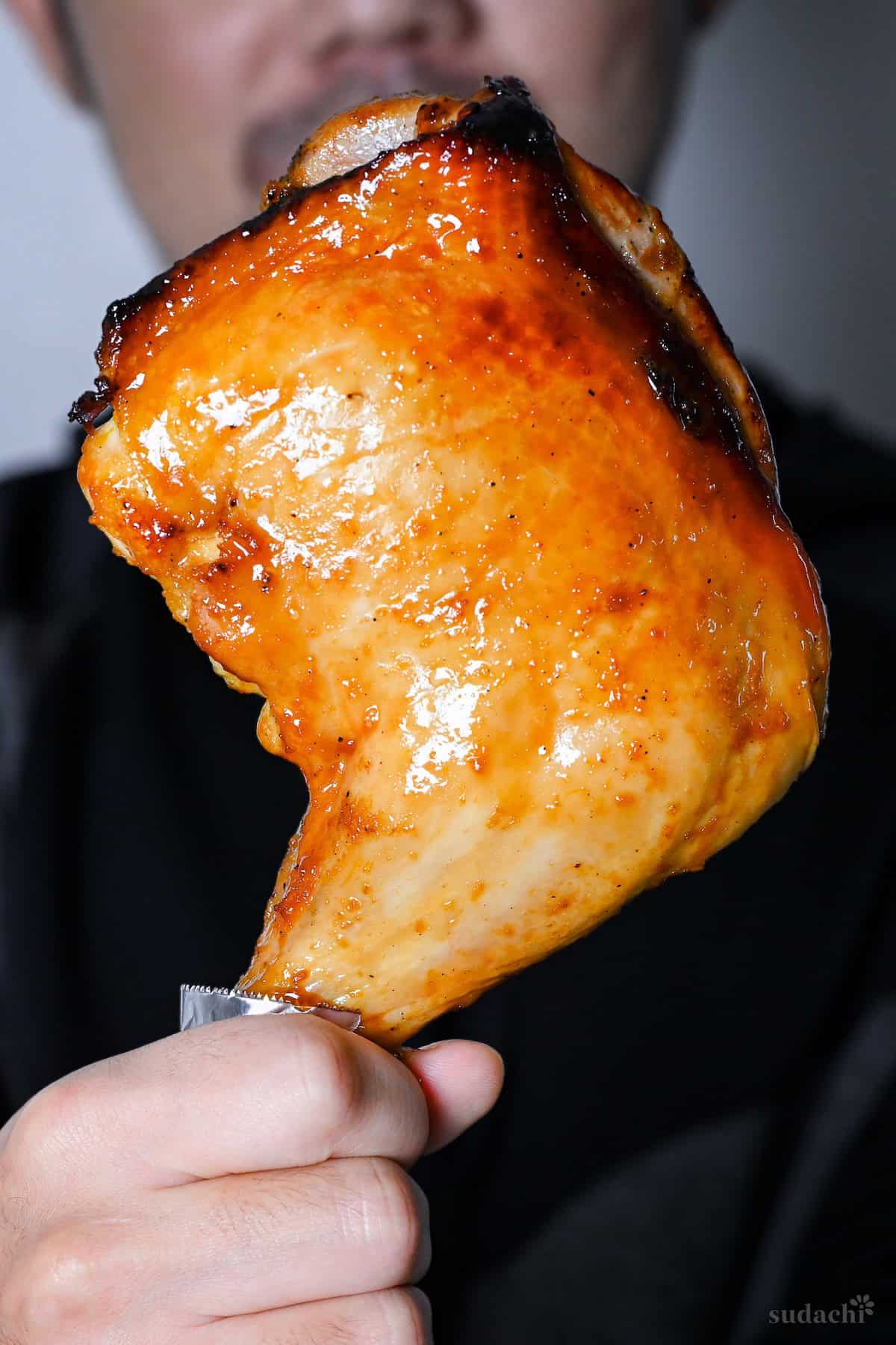 Yuto Omura holding a Japanese Christmas chicken leg quarter with soy glaze and yuzu