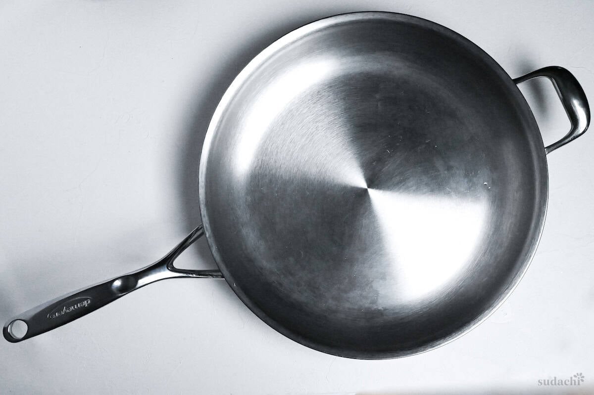 large stainless steel pan on a white background