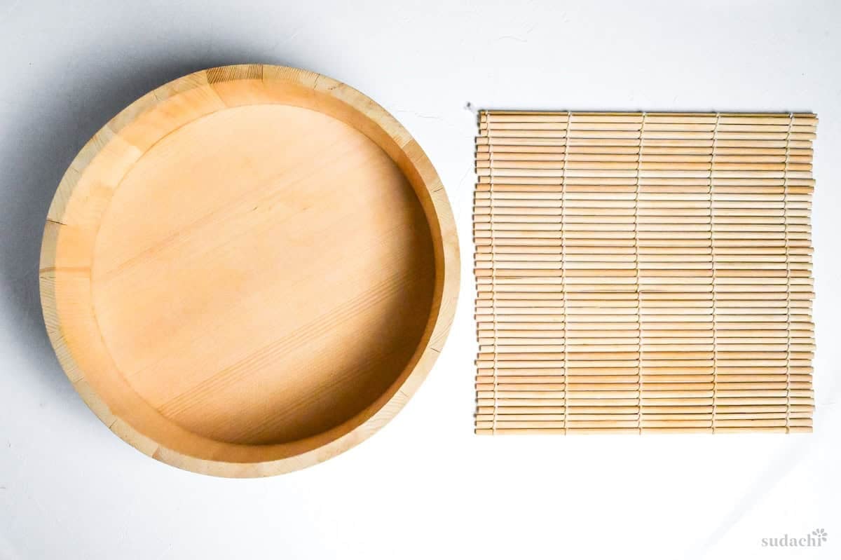 sushi oke and bamboo sushi rolling mat on a white background
