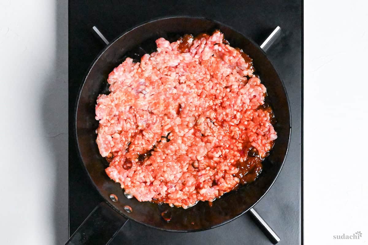 Ground pork spread in a layer in a frying pan