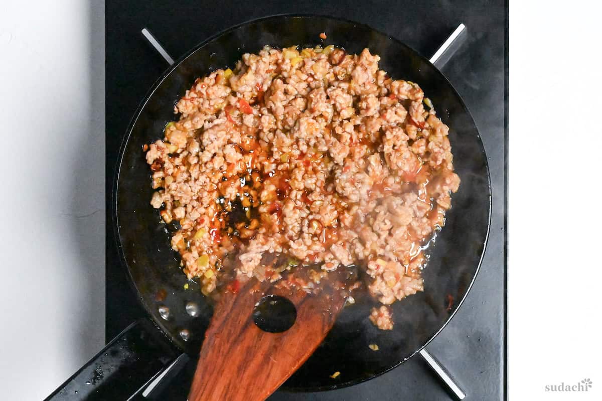 Seasoned pork for tantanmen frying in a pan on the stove top