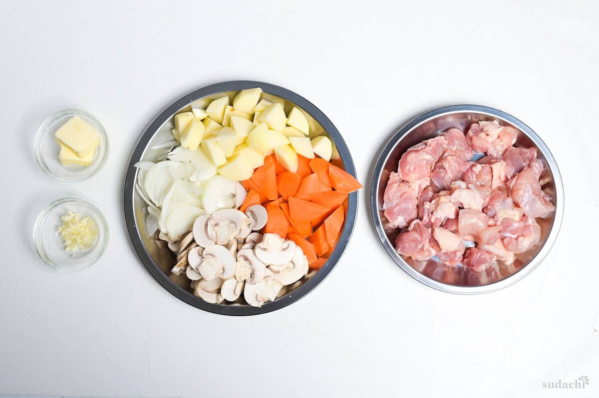 Mise en place for Japanese chicken cream stew (chicken and vegetables cut and ready to cook on steel plates)