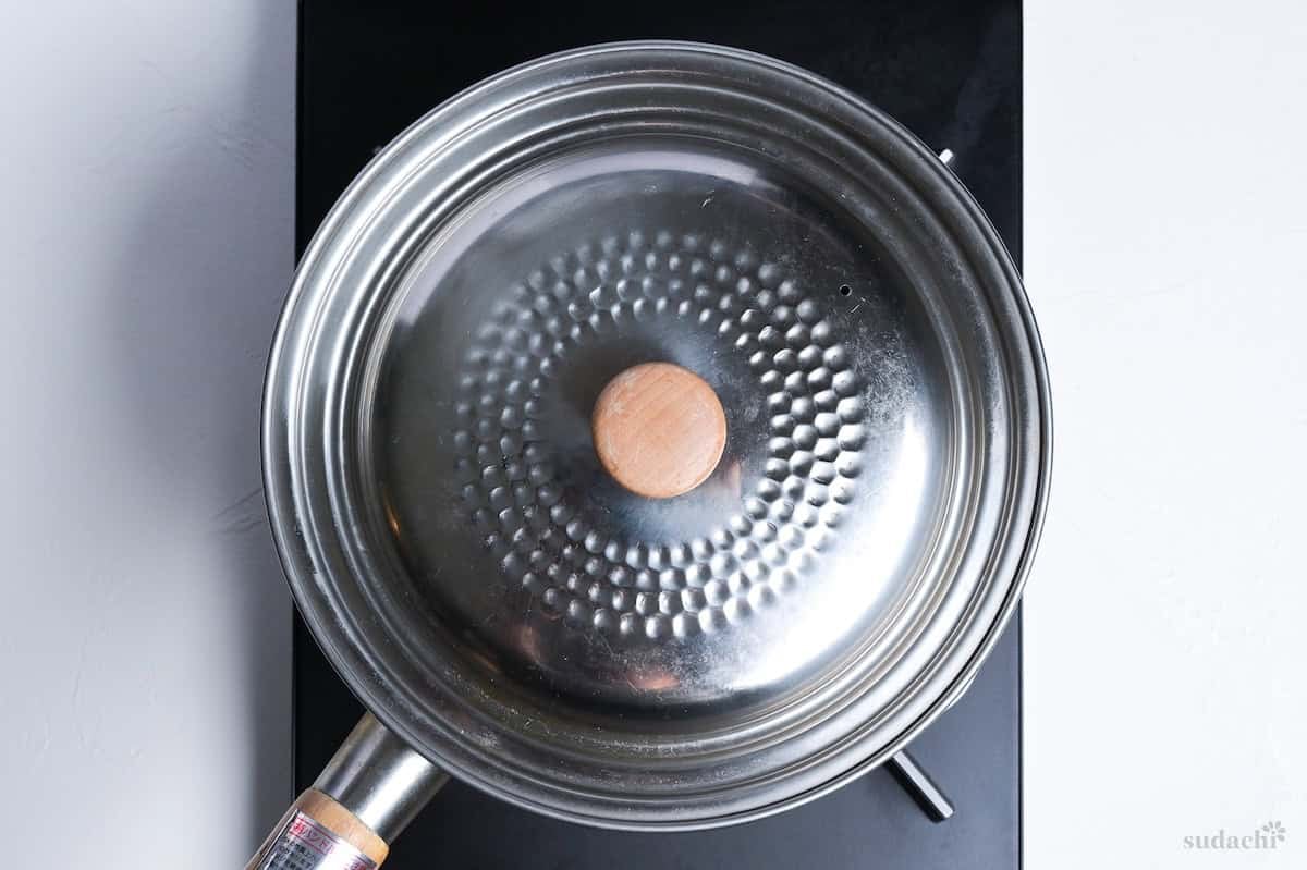 Japanese chicken cream stew simmering in a Japanese yukihira pot on the stove with a lid on