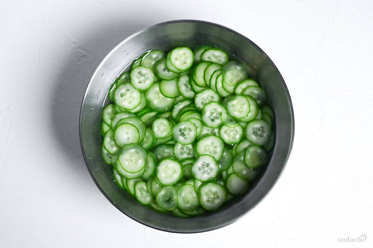 soaking thinly sliced Japanese cucumber in a bowl of lightly salted water