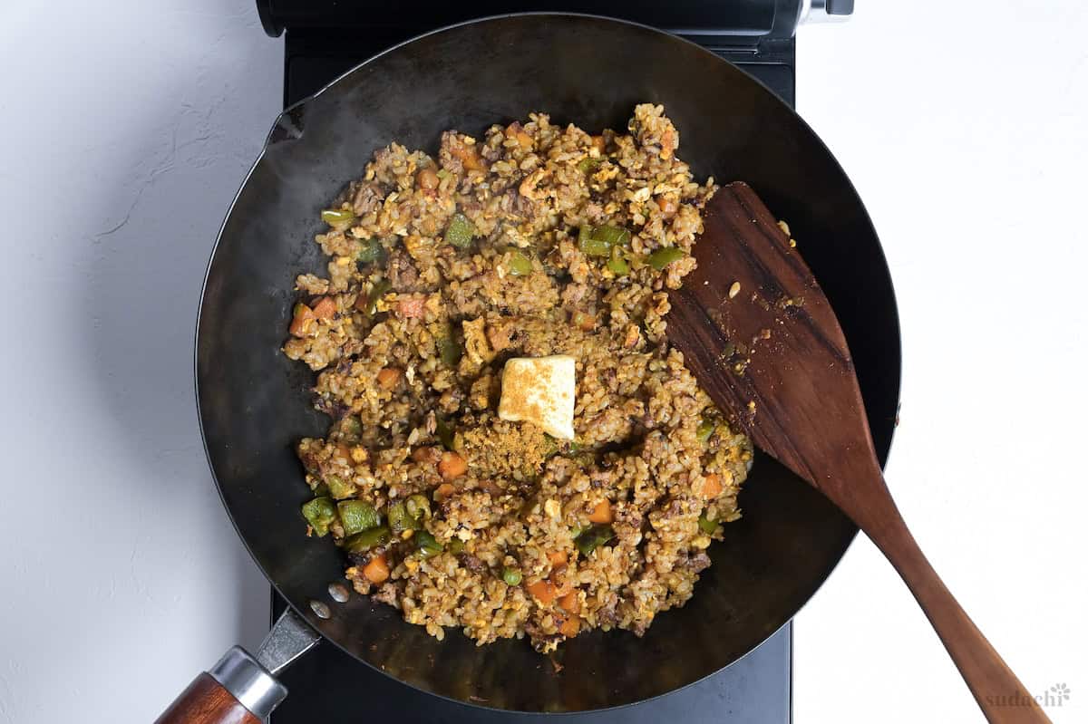 Japanese style curry fried rice in a wok with butter and garam masala