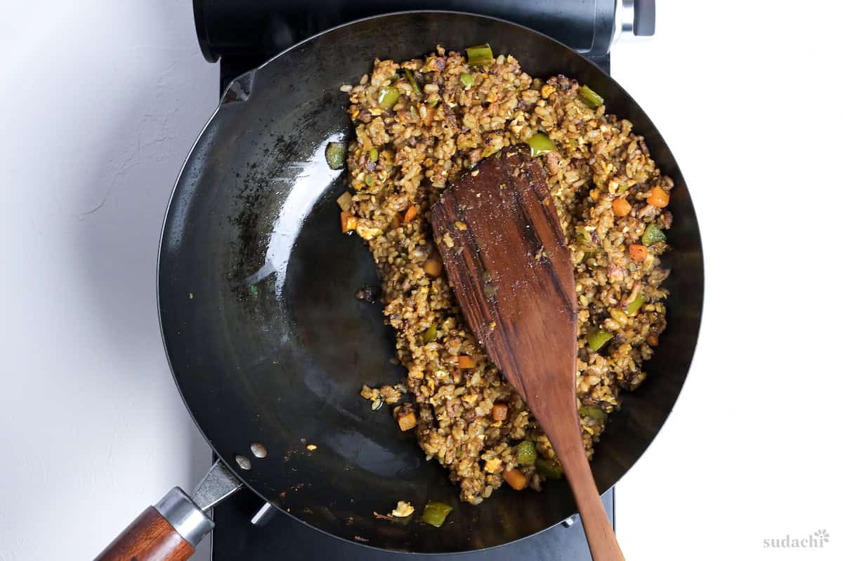 Japanese style curry fried rice pushed to one side of the wok