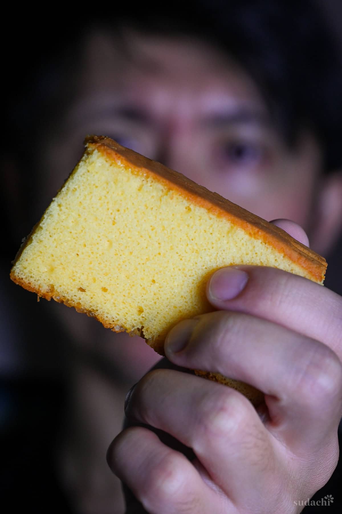 Yuto Omura holding up a piece of homemade Castella cake
