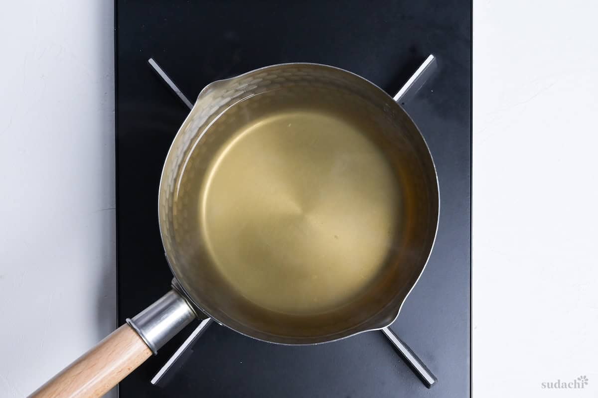 heating dashi in a Japanese yukihira pot on the stove top
