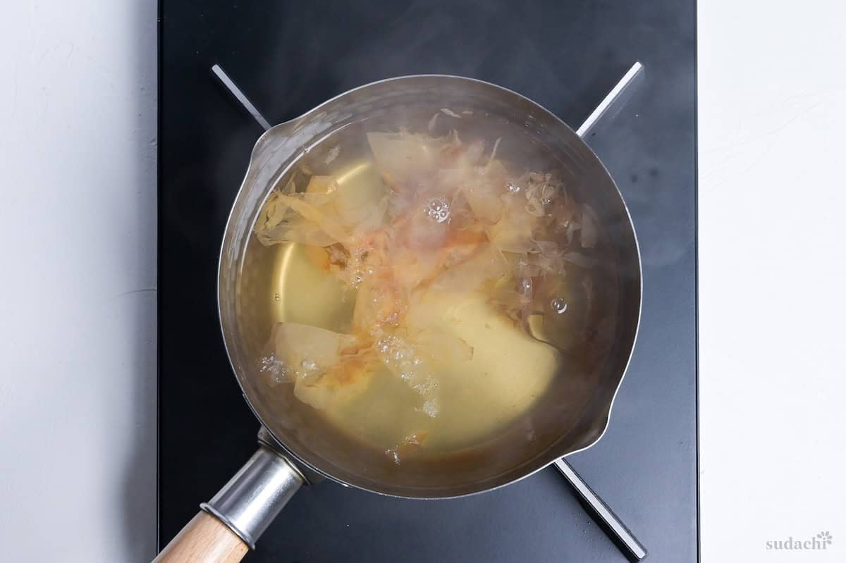 Bonito flakes soaking in dashi in a Japanese yukihira pot to make kake soba soup