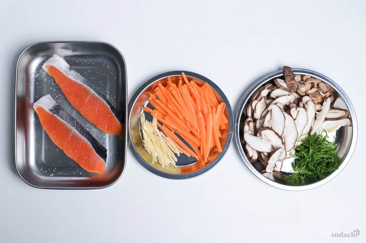 Ingredients for salmon maze gohan prepped and laid out on steel plates