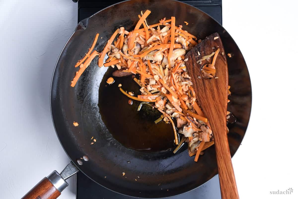 soy sauce added to empty space in the wok